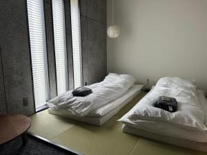 two beds in a room with two bags on them at The EKAI in Toyohashi
