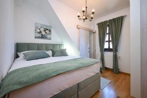 une chambre avec un grand lit et un lustre dans l'établissement Dvori Perdedaj, à Beretinec 63 autres photos