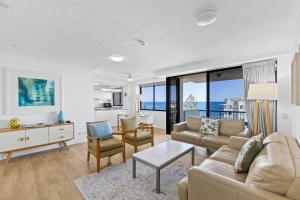 a living room with a couch and a table at Burgess @ Kings Beach Apartments in Caloundra