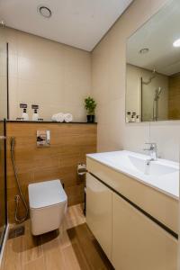 a bathroom with a sink and a toilet and a mirror at Comfortable 1 Bedroom with Balcony Vista 1 in Abu Dhabi
