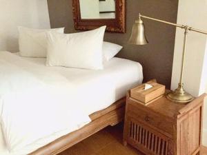 a bedroom with a bed and a lamp on a night stand at Rimklong boutique hotel trad in Trat
