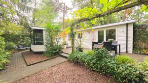 a backyard with a tiny house with a patio at Vliegend Hert, Direct in de Natuur op de Veluwe in Emst