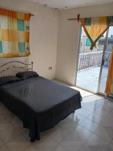 une chambre avec un lit et une grande fenêtre dans l'établissement Alojmiento centrico y cerca de la playa, à Veracruz