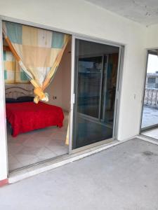 Cette chambre dispose d'une porte coulissante en verre avec un lit. dans l'établissement Alojmiento centrico y cerca de la playa, à Veracruz