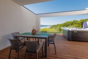a dining room with a table and chairs on a deck at Quantara Resort Domaša - Free Wellness in Holčíkovce
