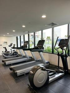 a gym with a row of treadmills and machines at Comfortable 1 Bedroom with Balcony Vista 1 in Abu Dhabi