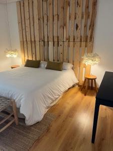 a bedroom with a large bed with a wooden wall at Casa Montaña de Riaño y Picos de Europa I in Riaño