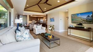 a living room with a white couch and a tv at HAWAIIAN DREAM Relaxing KaMilo 3BR Home with Private Beach Club in Waikoloa