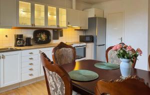 a kitchen with a table and chairs with a vase of flowers at 2 Bedroom Stunning Apartment In Högsby in Högsby