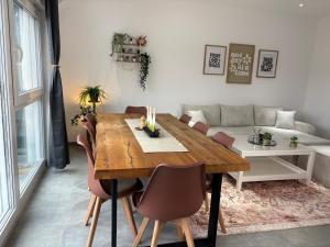 a dining room with a wooden table and chairs at Vollausgestattetes & harmonisches Wohlfühl Apartment in Saarbrücken +22 photos