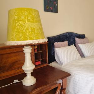 eine Lampe auf einem Tisch neben einem Bett in der Unterkunft Ballarat Heritage Retreat in Nerrina + 6 Fotos