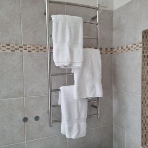 eine Dusche mit weißen Handtüchern auf einem Kleiderständer im Bad in der Unterkunft Ballarat Heritage Retreat in Nerrina