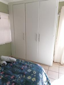 1 dormitorio con armarios blancos y 1 cama en Falcon Nest, en Kenton on Sea