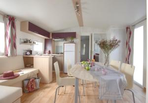 - une cuisine et une salle à manger avec une table et des chaises dans l'établissement Vakantiepark Koningshof, à Rijnsburg