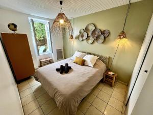 Un dormitorio con una cama con dos sombreros encima. en L'Instant Terrière - Quartier Calme - Proche plage, en La Tranche-sur-Mer