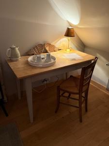 a wooden table with a lamp and a chair at Chambre Solognote in Saint-Pryvé-Saint-Mesmin