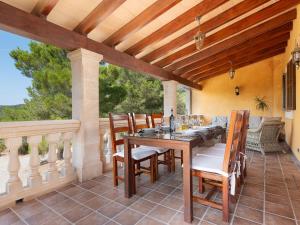 an outdoor dining room with a table and chairs at Finca s'Aguait in Portocolom