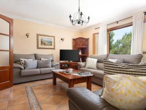 a living room with couches and a tv at Finca s'Aguait in Portocolom