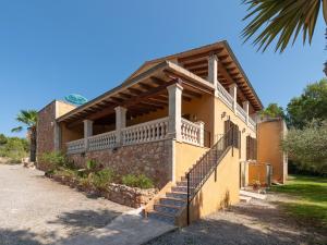 a building with a balcony and stairs on it at Finca s'Aguait in Portocolom