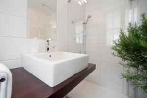 a white bathroom with a sink and a shower at Hotel Fischerhaus Bodman in Bodman-Ludwigshafen +35 photos