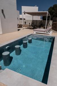 una piscina con taburetes frente a una casa en Elenitsa Villa with private pool, en Aliki