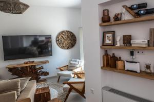 a living room with a couch and a tv at Elenitsa Villa with private pool in Aliki