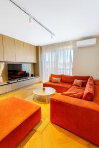 a living room with two orange couches and a table at Apartmán MONTARA in Donovaly