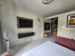 a living room with a bed and a tv on the wall at 2100 veranda condo Kembali in Davao City