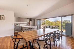 a kitchen and dining room with a wooden table and chairs at XYZ Holiday Home in Quindalup