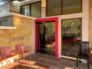 プロボリンゴにあるRedDoorz at The Canal Homestay Probolinggoの椅子と赤いドアのある会議室