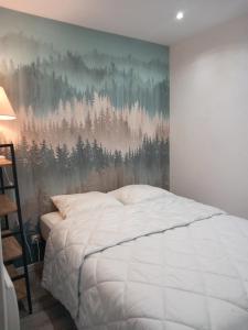 a bedroom with a bed and a painting on the wall at Appartement rdc maison Ed Den in Tauves