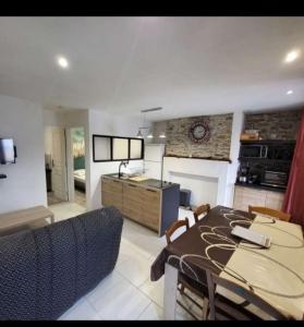 a kitchen and dining room with a table and chairs at Appartement rdc maison Ed Den in Tauves