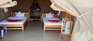 a room with two beds in a tent at Enchoro mara in Sekenani