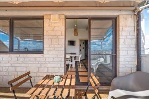 a brick house with glass doors and a patio at Golden Bay Lux House in Torre Lapillo