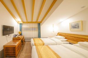 a hotel room with two beds and a television at Pipa Hotel Datong in Datong