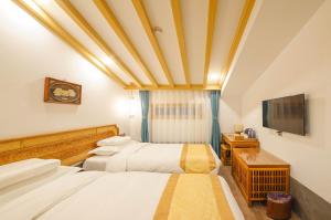 a hotel room with two beds and a television at Pipa Hotel Datong in Datong
