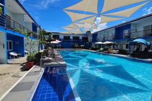 a large swimming pool with a large umbrella and a building at Casa Blu Hotel & Resort in Maribago