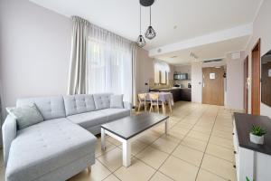 a living room with a couch and a table at ApartamentyPrzyMorzu Olympic Park z Prywatnym Tarasem z Widokiem Na Morze in Kołobrzeg