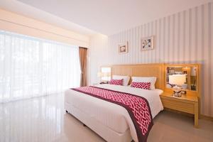 a bedroom with a large bed and a large window at The Par Phuket Hotel in Ban Thung Thong