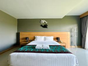 a bedroom with a large bed in a room at The Par Phuket Hotel in Ban Thung Thong