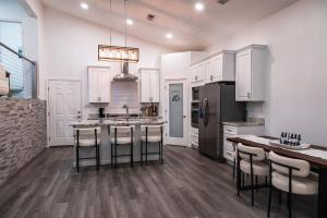 a kitchen with white cabinets and a island with bar stools at New House in the Palisades Hills in Albuquerque