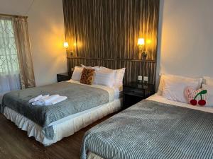 a hotel room with two beds and a window at Hotel Purnama Lenggang in Gantung +9 photos