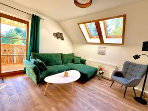 a living room with a green couch and a table at Savor Appartement Bergblick für 6 Personen in Sohland