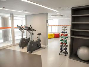 Un gimnasio con cintas de correr y elípticas en una habitación. en Mercure Jundiai Shopping, en Jundiaí