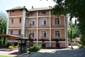 a large orange building with windows on a street at Hotel Tintyava 2 in Varshets