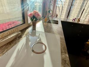 a bathroom with a ring on a table with a vase of flowers at Stadthaus Amanda in Weimar