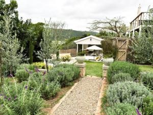 un jardin avec des plantes et une maison en arrière-plan dans l'établissement Ginger Lake Wilderness, à Wilderness
