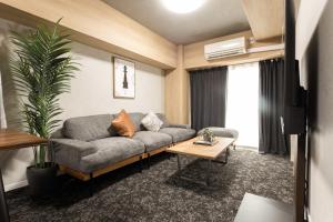 a living room with a couch and a table at b&難波1号店 in Osaka