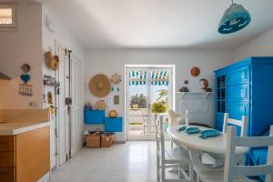 eine Küche mit blauen Schränken und einem Tisch mit Stühlen in der Unterkunft Sea View Terrace in Santa Caterina di Nardò