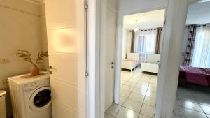 a laundry room with a washing machine and a living room at Trilocale con giardino, posto auto e wi-fi - P034 in Porto Recanati